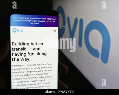 Stuttgart, Allemagne, 06-12-2024 : personne tenant un téléphone portable avec la page web de la société de mobilité américaine via Transportation Inc (RideWithVia) avec le logo. Concentrez-vous sur Banque D'Images