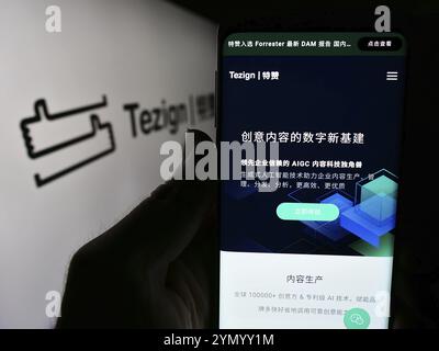 Stuttgart, Allemagne, 05-15-05 2024 : personne tenant un smartphone avec le site Web de la société chinoise d'analyse de contenu Tezign devant le logo de l'entreprise. Concentrez-vous sur Banque D'Images