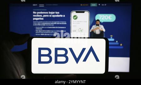 Stuttgart, Allemagne, 03-01-2024 : personne tenant un téléphone portable avec le logo de la société Banco Bilbao Vizcaya Argentaria S.A. (BBVA) en face de la page web de l'entreprise Banque D'Images