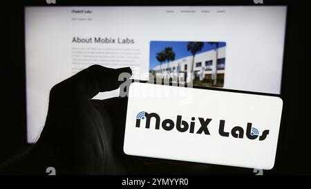 Stuttgart, Allemagne, 05-03-2024 : personne tenant un smartphone avec le logo de la société américaine de semi-conducteurs sans usine Mobix Labs Inc en face du site Web. Concentrez-vous sur Banque D'Images