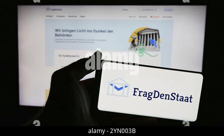 Stuttgart, Allemagne, 05-21-05 2024 : personne tenant un smartphone avec le logo de l'organisation non gouvernementale allemande FragDenStaat devant le site web. Concentrez-vous sur Banque D'Images