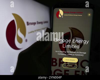 Stuttgart, Allemagne, 05-06-2024 : personne tenant un téléphone portable avec la page Web de la compagnie pétrolière émirati Brooge Energy Limited devant le logo. Concentrez-vous sur ce Banque D'Images