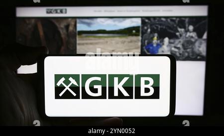 Stuttgart, Allemagne, 04-07-2024 : personne tenant un smartphone avec le logo de la société autrichienne GKB Bergbau GmbH devant le site. Se concentrer sur l'affichage du téléphone, Banque D'Images