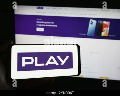 Stuttgart, Allemagne, 05-23-2024 : personne tenant un smartphone avec le logo de la société polonaise de télécommunications P4 sp. z o.o. (jouer) devant le site Web. FOC Banque D'Images