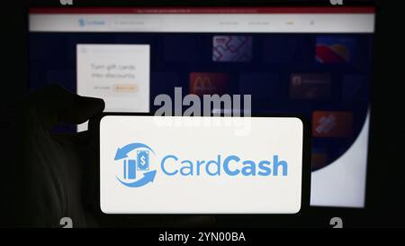 Stuttgart, Allemagne, 04-29-2024, personne tenant un téléphone portable avec le logo de la société américaine CardCash de place de marché de cartes-cadeaux en face de la page Web de l'entreprise. Concentrez-vous sur Banque D'Images