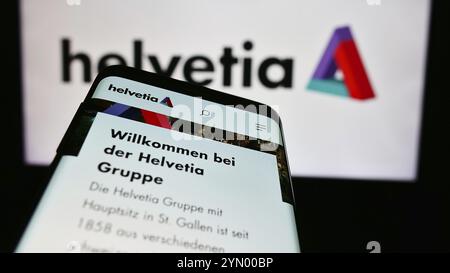 Stuttgart, Allemagne, 05-31-2024, smartphone avec page web de la compagnie d'assurance suisse Helvetia Holding AG devant le logo de l'entreprise. Concentrez-vous sur le coin supérieur gauche de Banque D'Images