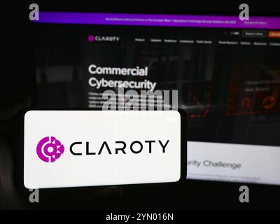 Stuttgart, Allemagne, 07-11-2024 : personne tenant un smartphone avec le logo de la société de cybersécurité Claroty Ltd devant le site. Concentrez-vous sur l'affichage du téléphone Banque D'Images