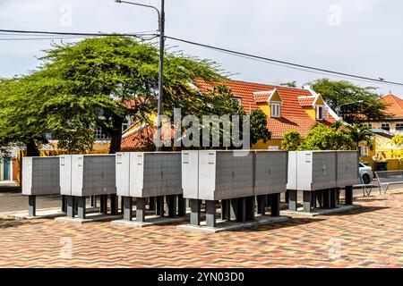 Une boîte aux lettres communale sur une place publique dans le district d'Otrabanda à Willemstad, Curaçao. À Curaçao, le courrier n’est traditionnellement pas livré à la porte des gens ; au lieu de cela, les résidents utilisent des boîtes aux lettres numérotées aux points de collecte centraux installés dans les zones résidentielles. Le quartier Otrabanda de Willemstad est un site classé au patrimoine mondial de l'UNESCO et est connu pour sa vie culturelle animée et ses nombreuses peintures murales. Curaçao, Kòrsou Banque D'Images