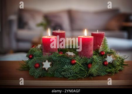 Deuxième Avent, couronne verte avec des boules de Noël, biscuits étoile à la cannelle et bougies rouges, deux sont allumés, sur une table dans le salon, espace copie, sel Banque D'Images