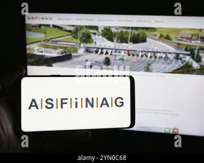 Stuttgart, Allemagne, 06-11-2024 : personne tenant un smartphone avec le logo de la société autrichienne d'infrastructures autoroutières ASFINAG en face du site. Concentrez-vous sur Banque D'Images