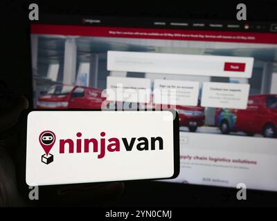 Stuttgart, Allemagne, 05-16-05 2024 : personne tenant un smartphone avec le logo de la société de livraison singapourienne Ninja Logistics Pte. Ltd en face du site Web. FOC Banque D'Images
