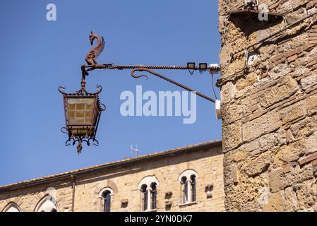 Ancien lampadaire médiéval sur la façade de la place principale de Volterra, Italie, Europe Banque D'Images