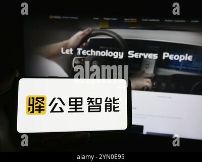 Stuttgart, Allemagne, 05-16-05 2024 : personne tenant un smartphone avec le logo de la société de technologie chinoise Yigongli Intelligence (1KMXC) en face du site Web. F Banque D'Images