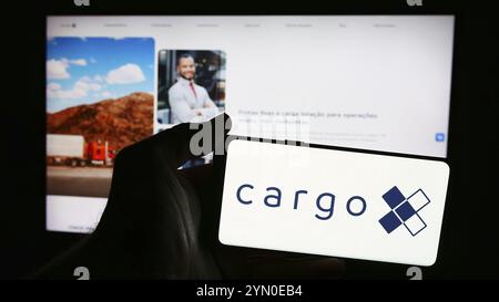 Stuttgart, Allemagne, 06-06-2024 : personne tenant un téléphone portable avec le logo de la société brésilienne de plate-forme logistique CargoX en face de la page Web de l'entreprise. FO Banque D'Images