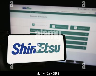 Stuttgart, Allemagne, 04-13-2024 : personne tenant un smartphone avec le logo de la société japonaise de produits chimiques Shin-Etsu Chemical Co. Ltd en face du site Web. FOC Banque D'Images