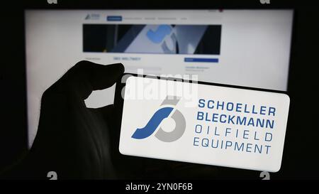 Stuttgart, Allemagne, 04-07-2024 : personne tenant un téléphone portable avec le logo de la société Schoeller-Bleckmann Oilfield Equipment AG devant le business web PA Banque D'Images