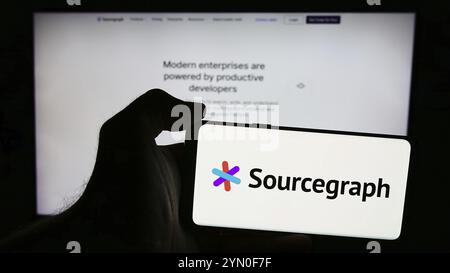 Stuttgart, Allemagne, 07-11-2024 : personne tenant un téléphone portable avec le logo de la société américaine de renseignement de code Sourcegraph Inc en face de la page web. FOC Banque D'Images