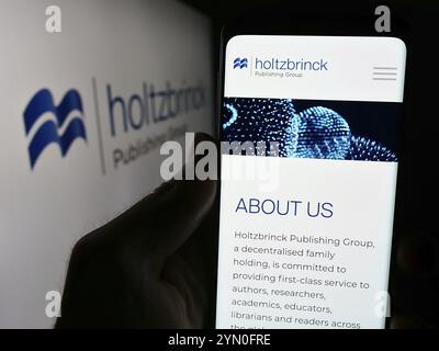 Stuttgart, Allemagne, 05-22-2024 : personne tenant un smartphone avec le site web de la société de médias allemande Holtzbrinck Publishing Group devant le logo. Concentrez-vous sur Banque D'Images