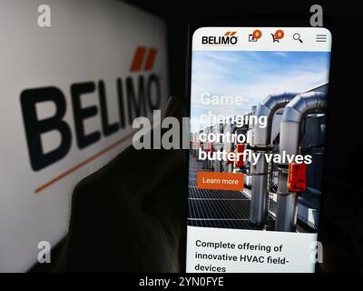 Stuttgart, Allemagne, 05 31 2024 : personne tenant un téléphone portable avec la page web de la société suisse de systèmes de contrôle Belimo Holding AG devant le logo. Concentrez-vous sur ce Banque D'Images