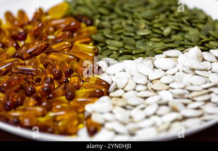 Graines de citrouille en différentes versions, huile de graines riche en nutriments pour le traitement de la prostate, la santé des hommes, le magnésium, cardiovasculaire. Banque D'Images