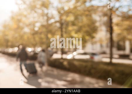 Une photo floue d'une rue avec des voitures et des arbres. La photo a une qualité rêveuse et brumeuse, comme si elle était prise à travers une fenêtre brumeuse. Banque D'Images
