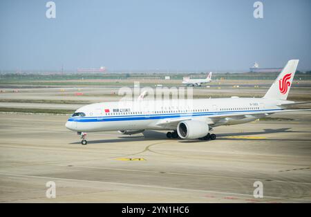 Shanghai, Chine - 04 novembre 2024 : Airbus d'Air China sur la piste de l'aéroport international de Shanghai Pudong. Avion et porte-conteneurs de l'est de la Chine Banque D'Images