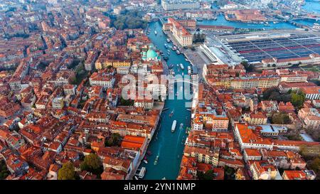 Une vue aérienne panoramique sur les toits et les canaux historiques de Venise avec le lagon scintillant en arrière-plan, parfait pour explorer le patrimoine italien Banque D'Images