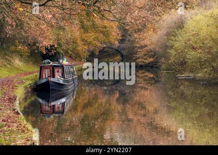 Bateau étroit sur Leeds et Liverpool canal reflété dans l'eau à Adlington près de Chorley, Lancashire UK Banque D'Images