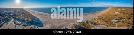 Panorama drone sur la plage de Vejers au Danemark avec soleil et neige en hiver Banque D'Images