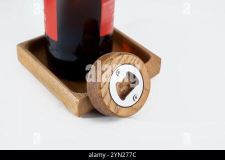 petit ouvre-bouteille rond de palme en bois pratique avec plateau de boissons de bouteille isolé sur un fond blanc Banque D'Images