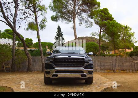 Le Dodge Ram Limited noir avec des accents chromés est garé parmi les pins à Campulungu, Villasimius, entouré d'une végétation luxuriante et de la beauté sereine de Banque D'Images