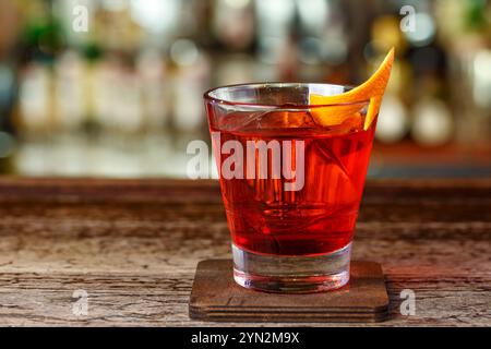 Recette traditionnelle Negroni - gin, campari et martini rosso. Le cocktail se tient sur l'arrière-plan flou de la barre Banque D'Images