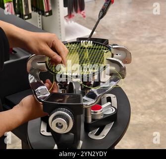 Cordes une raquette de badminton sur une machine à cordes de raquettes. Banque D'Images