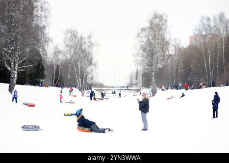 Korolev 08.01.202 - vacances d'hiver, des enfants heureux avec des parents à cheval sur un tube et s'amuser à l'extérieur en hiver Banque D'Images