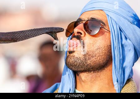 Un charmeur de serpents dans un turban bleu prétend chérir ses reptiles Banque D'Images