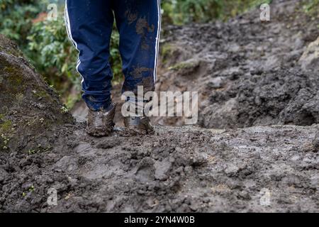 Un gros plan d'un sentier boueux et d'un homme qui a des bottes boueuses, debout immobile à Khumbu, Népal. Banque D'Images