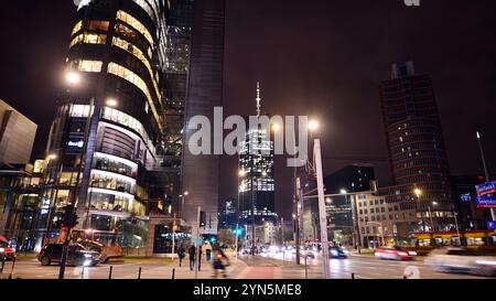 Varsovie, Pologne. 21 novembre 2024. Photographie de rue de voitures dans la rue la nuit. Les traînées de lumière sur le fond du bâtiment moderne. Banque D'Images