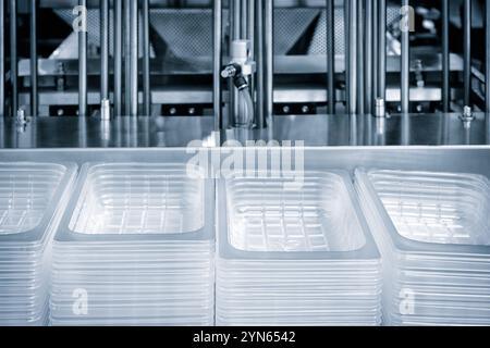 Machine automatique de production de sacs en plastique polyéthylène avec effet d'éclairage. Gros plan du rouleau de la machine de production de sacs en plastique à la lumière Banque D'Images