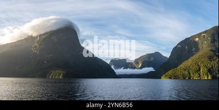 Le soleil se lève sur le Doubtful Sound, les nuages s'accrochant sur les montagnes, l'île du Sud de la Nouvelle-Zélande Banque D'Images