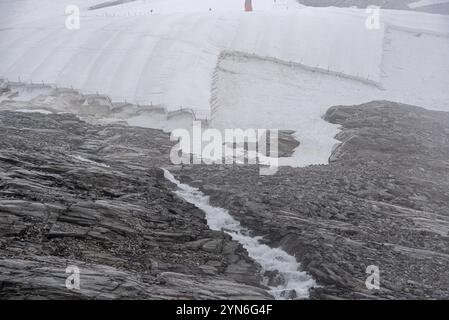 Une grande bâche de neige protégeant la glace du glacier Hintertux dans les Alpes, une piste de ski mène entre les deux, Autriche, Europe Banque D'Images