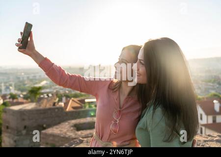 Deux jeunes femmes prenant selfie ensemble dans la ville Banque D'Images