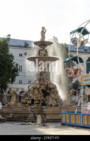 Tôt le matin à la Fontaine baroque sur la place Residenz à Salzbourg, Une grande roue pour enfants en arrière-plan, Autriche, Europe Banque D'Images