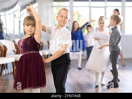 Tween filles ad garçons dansant la danse partenaire lente pendant l'événement festif Banque D'Images