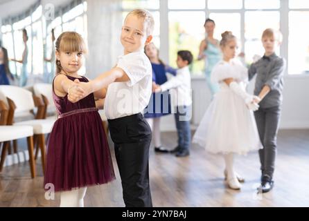 Tween filles ad garçons dansant la danse partenaire lente pendant l'événement festif Banque D'Images