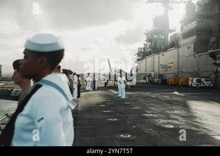 Les marins affectés au navire d'assaut amphibie USS Boxer (LHD 4) et les Marines américains affectés à la 15e Marine Expeditionary Unit manquent les rails alors que le Boxer quitte la base conjointe Pearl Harbor-Hickam, Hawaï, 15 novembre 2024. Des éléments de la 15e MEU sont actuellement embarqués à bord de Boxer et mènent des opérations de routine dans la 3e flotte américaine. (Photo du corps des Marines des États-Unis par le Cpl Luis Agostini) Banque D'Images