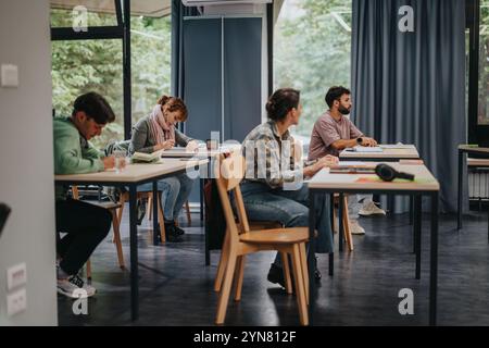 Les étudiants écoutent attentivement le professeur âgé en classe Banque D'Images
