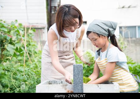 Parents et enfants lavant les légumes Banque D'Images