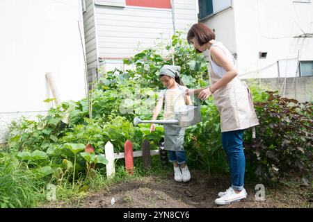 Parent et enfant arrosant le champ Banque D'Images