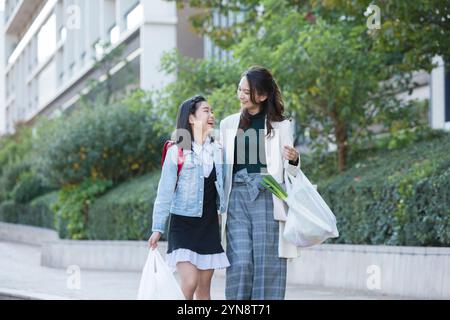 Parent et enfant souriants sur le chemin de la maison après le shopping Banque D'Images