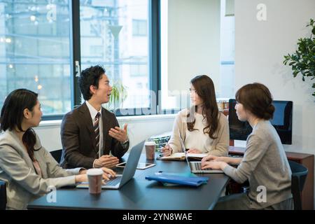 Hommes et femmes souriant et parlant pendant le travail de bureau Banque D'Images